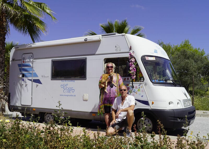 mand og kvinde poserer foran en autocamper