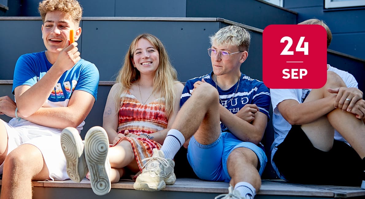 Fire teenagere sidder på en udendørs trappe, smiler og taler. En pige har en batikfarvet kjole på, og de andre har afslappet sommertøj på. Et rødt kalenderikon viser 24. SEP øverst til højre i billedet.