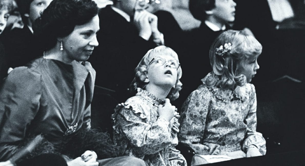 Prinsesse Benedikte sammen med sine to døtre, prinsesse Alexandra og prinsesse Nathalie, ved Dronning Ingrids 70 års fødselsdag den 28. marts 1980. I baggrunden ses prinserne Frederik og Joachim.